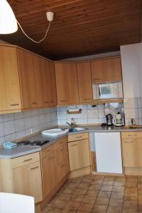 eine Küche mit Holzschränken und einer Arbeitsplatte in der Unterkunft Ferienwohnung Seidenfaden in Karlstadt