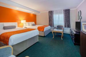 ein Hotelzimmer mit 2 Betten und einem TV in der Unterkunft Howard Johnson Plaza by Wyndham Windsor in Windsor