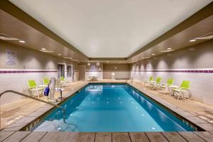 a pool in a hotel room with chairs and a table at La Quinta by Wyndham Cedar City in Cedar City +22 photos