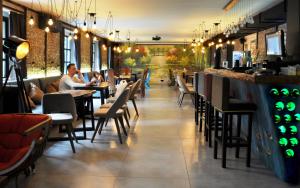 a restaurant with people sitting at tables and a bar at Art Hotel Claude Monet in Tbilisi City