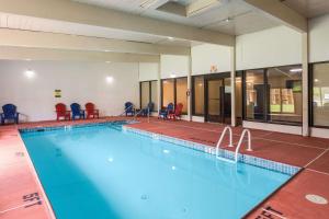 - une grande piscine avec des chaises rouges dans un bâtiment dans l'établissement Pocono Inn & Banquet - Stroudsburg, à Delaware Water Gap