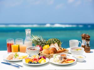a breakfast table with breakfast foods and drinks on the beach at Sheraton Okinawa Sunmarina Resort in Onna