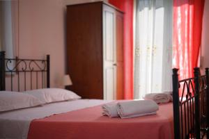 1 dormitorio con 2 camas y cortinas rojas en B&B Porta del Re, en Taormina