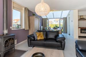 uma sala de estar com um sofá de couro e um fogão em Maxime 203 - Kustpark Village Scaldia em Hoofdplaat