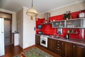 a red kitchen with a stove and a red wall at Family apartment in the heart of Rivne in Rivne
