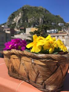 a vase filled with yellow flowers sitting on top of a table at B&B Porta del Re in Taormina