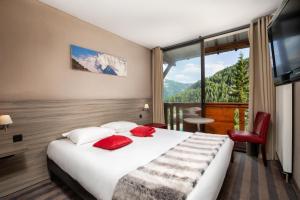 a hotel room with a bed and a large window at SOWELL Family Les Bergers in Pra-Loup