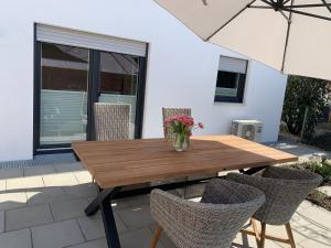 uma mesa de madeira com cadeiras e um vaso de flores em Ferienwohnung Susanne em Bad Krozingen