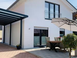 eine Terrasse mit einem Tisch und einem Sonnenschirm in der Unterkunft Ferienwohnung Susanne in Bad Krozingen