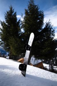 ein Snowboard auf einem Schneehaufen in der Unterkunft Hotel Bellwald in Bellwald