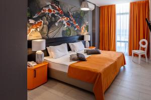 a bedroom with a large bed with an orange blanket at Design Hotel Skopeli in Odesa