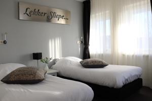 een slaapkamer met 2 bedden en een bord met een betere nachtrust bij Stadsherberg 'Het Wapen van IJlst' in IJlst