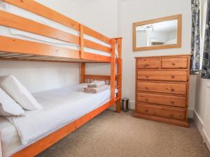 a bedroom with two bunk beds and a dresser at 1 Organsdale Cottages in Kelsall Hill