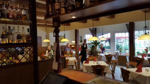 a restaurant with tables and people standing in a room at Hostel Schweriner See in Retgendorf
