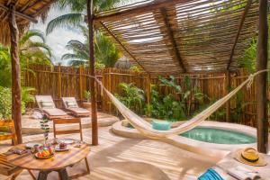 a hammock in the middle of a patio with a pool at Viceroy Villas, Riviera Maya in Playa del Carmen