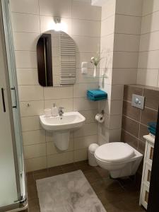 y baño con lavabo, aseo y espejo. en APARTAMENT AST en Władysławowo