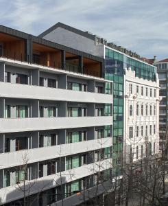 een kantoorgebouw met een glazen gevel naast een gebouw bij Nôma Living Pop Saldanha in Lissabon