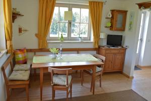 une cuisine avec une table et des chaises et une télévision dans l'établissement Ferienwohnung Gassoid, à Fieberbrunn