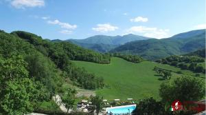 vista para um vale com piscina e montanhas em Guest house Agriturismo i Conti CIR 16277 em Urbania