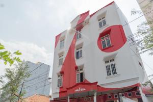 un bâtiment blanc et rouge avec une garniture rouge dans l'établissement OYO 1111 Pasar Baru Inn, à Jakarta