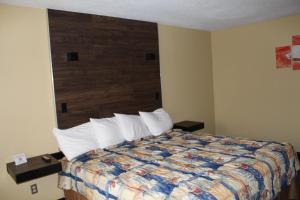 a hotel room with a bed with a wooden headboard at Mansion View Inn & Suites in Springfield