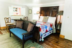 a bedroom with a bed and a couch and a chair at Roanoke Island Inn in Manteo