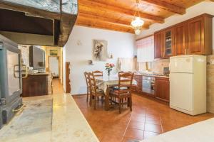 a kitchen with a table and chairs and a white refrigerator at Villa Roža in Žminj