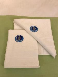 une serviette blanche avec deux badges bleus dessus dans l'établissement MOBI DICK Family Hotel, à Glavatartsi