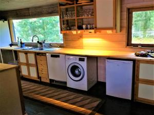 eine Küche mit Waschmaschine und Trockner unter der Arbeitsplatte in der Unterkunft Villa Pellinki in Pellinki