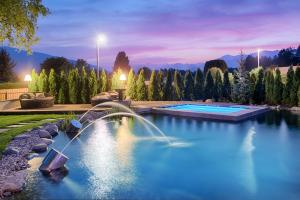 a swimming pool with a fountain in a yard at Majestic Hotel & Spa Resort in Brunico