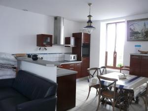 a kitchen and a living room with a table and chairs at Ker Corentine, maison de charme à Benodet, jardin in Bénodet