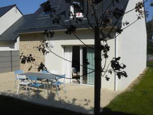 uma mesa e cadeiras em frente a uma casa em Rivage, Belle villa à Carnac Plage em Carnac