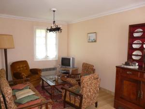 ein Wohnzimmer mit einem Sofa, Stühlen und einem TV in der Unterkunft Laraon, maison à Pouldreuzic in Pouldreuzic