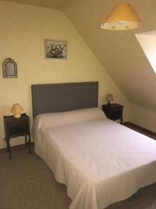 - une chambre avec un lit blanc et 2 tables de chevet dans l'établissement Laraon, maison à Pouldreuzic, à Pouldreuzic
