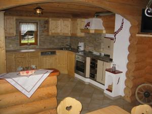 a kitchen in a log cabin with a stove top oven at Tomperkasa in Apriach
