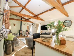 a living room with wooden ceilings and a table at Snave Cottage in Skipton