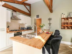 a kitchen with a wooden counter top and a sink at Snave Cottage in Skipton