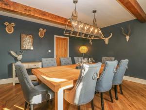 a dining room with a wooden table and blue chairs at Skyfell in Skipton