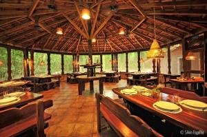 a restaurant with tables and chairs and a large ceiling at Aymara Lodge in Poconé