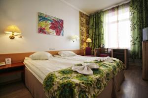 Una habitación de hotel con una cama con una bata. en A1 Hotel Riga City Center en Riga