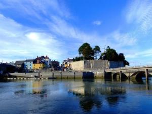 a bridge over a body of water next to a city at Cardigan Castle in Cardigan