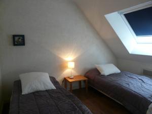 een zolderkamer met 2 bedden en een lamp bij Ty Kreisker in Carnac