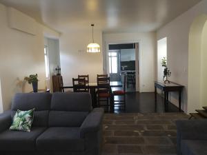 a living room with a couch and a dining room at Quinta São José da Relva in Ponta Delgada