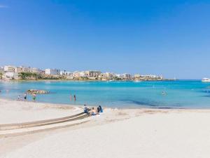 un gruppo di persone sedute sulla spiaggia di Casa vacanze venere centro storico Otranto, Salento 4 posti a Otranto