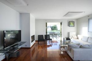 - un salon avec un canapé blanc et une télévision dans l'établissement Voula, A modern, minimal and stylish, apartment, à Athènes