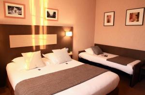 Cama ou camas em um quarto em Logis Hôtels- Hôtel Marguerite d'Anjou Angers château