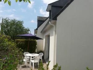 a patio with a table and chairs and an umbrella at KREISKER 3 - Maison Jumelée, Jardin - CA6009 in Carnac