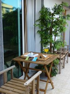 une table en bois et des bancs sur une terrasse dans l'établissement AZORES HOLIDAYS HOUSE -B&B - Suites - Self Check-in KEYBOARD, à Ponta Delgada