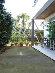 um pátio com uma cerca, uma mesa e árvores em AZORES HOLIDAYS HOUSE -B&B - Suites - Self Check-in KEYBOARD em Ponta Delgada