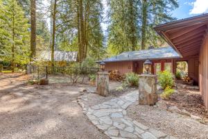 a home for sale in the woods with a pathway and a house at Retreat on the Salmon River in Welches